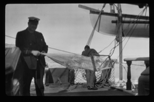 Image of Two men aboard, with nets on frame